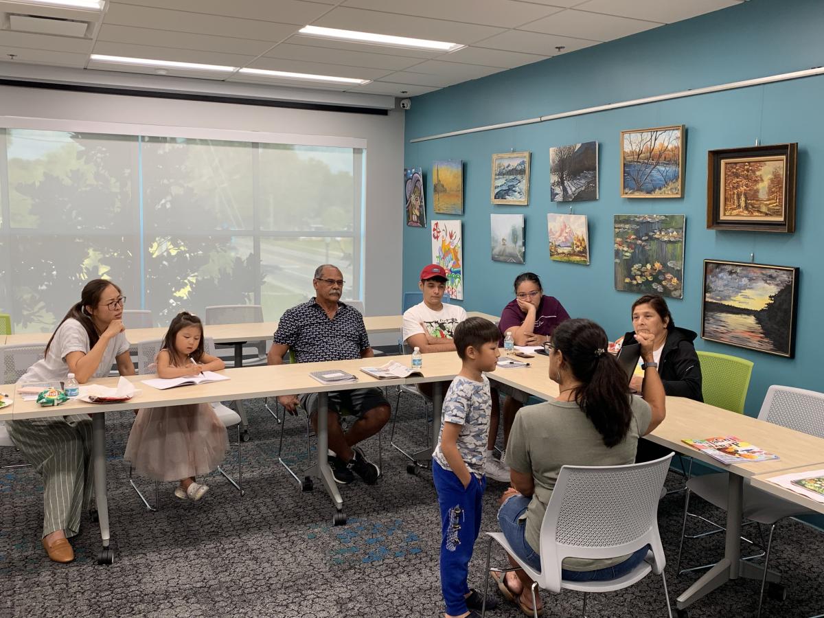 A group of families listen to a story. 